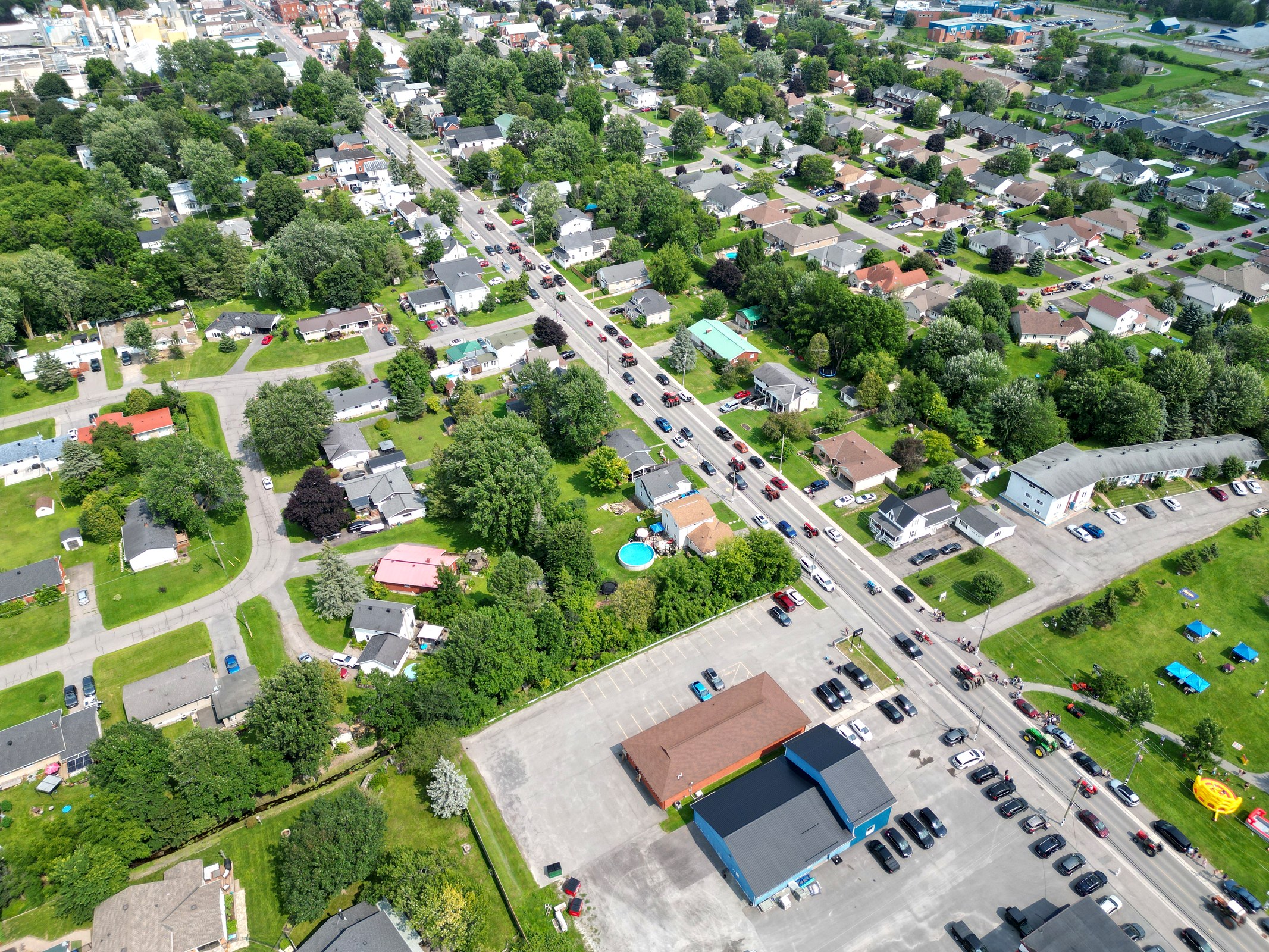 Aerial view of tractors displayed in rows at a rural community event